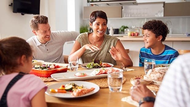 Familie snakker sammen rundt middagsbordet uten synlige skjermer